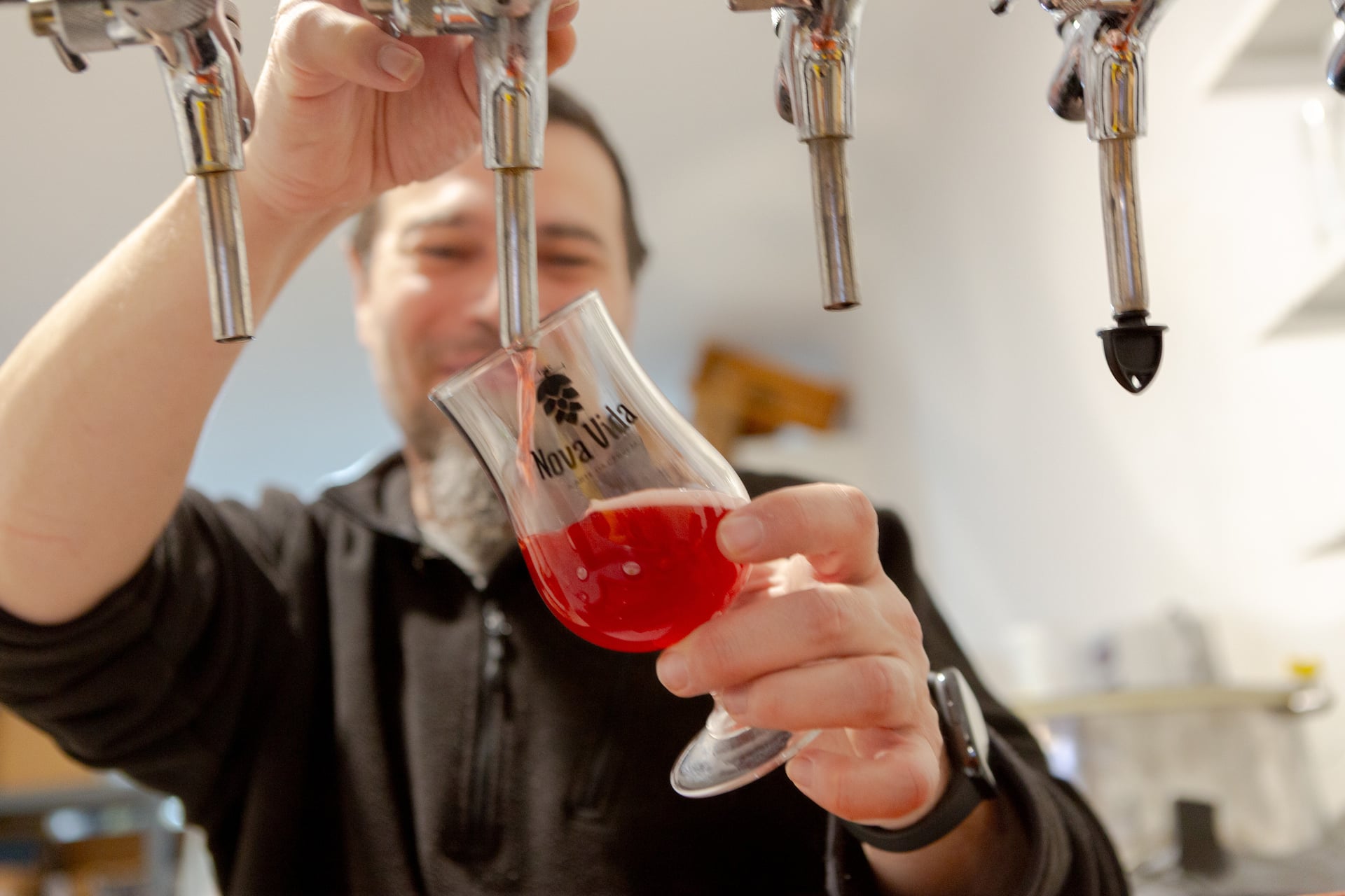 Copo de cerveja artesanal Nova Vida enchido nas torneiras da cervejaria